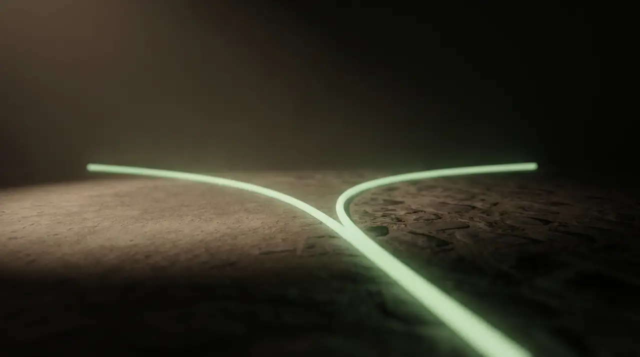 two paths of green light diverging across dark ground